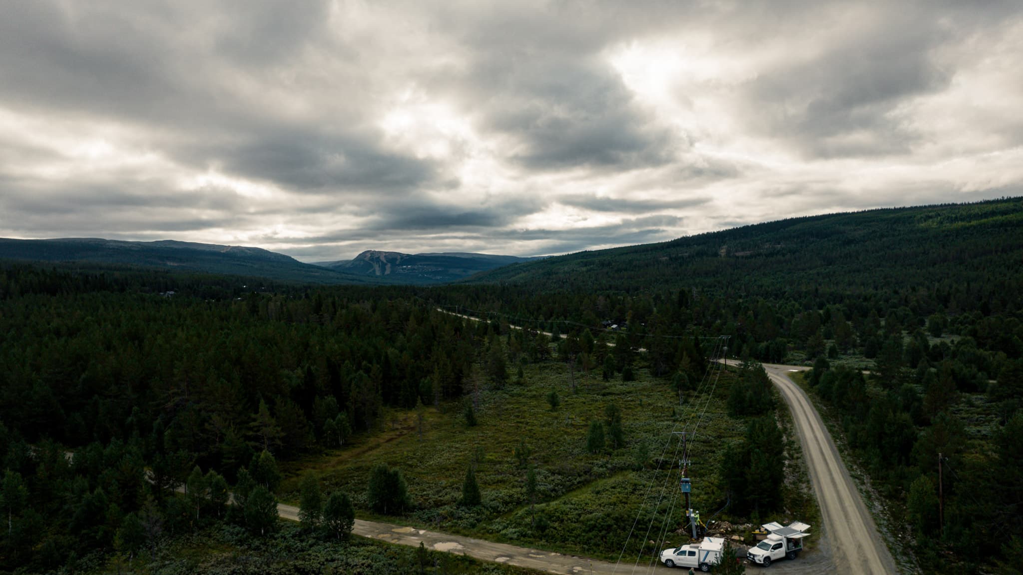 Arbetsfordon från BTEA som används för att utföra elnätsunderhåll i Jämtland. Utsikt mot skidbackar bortom elledningarna.