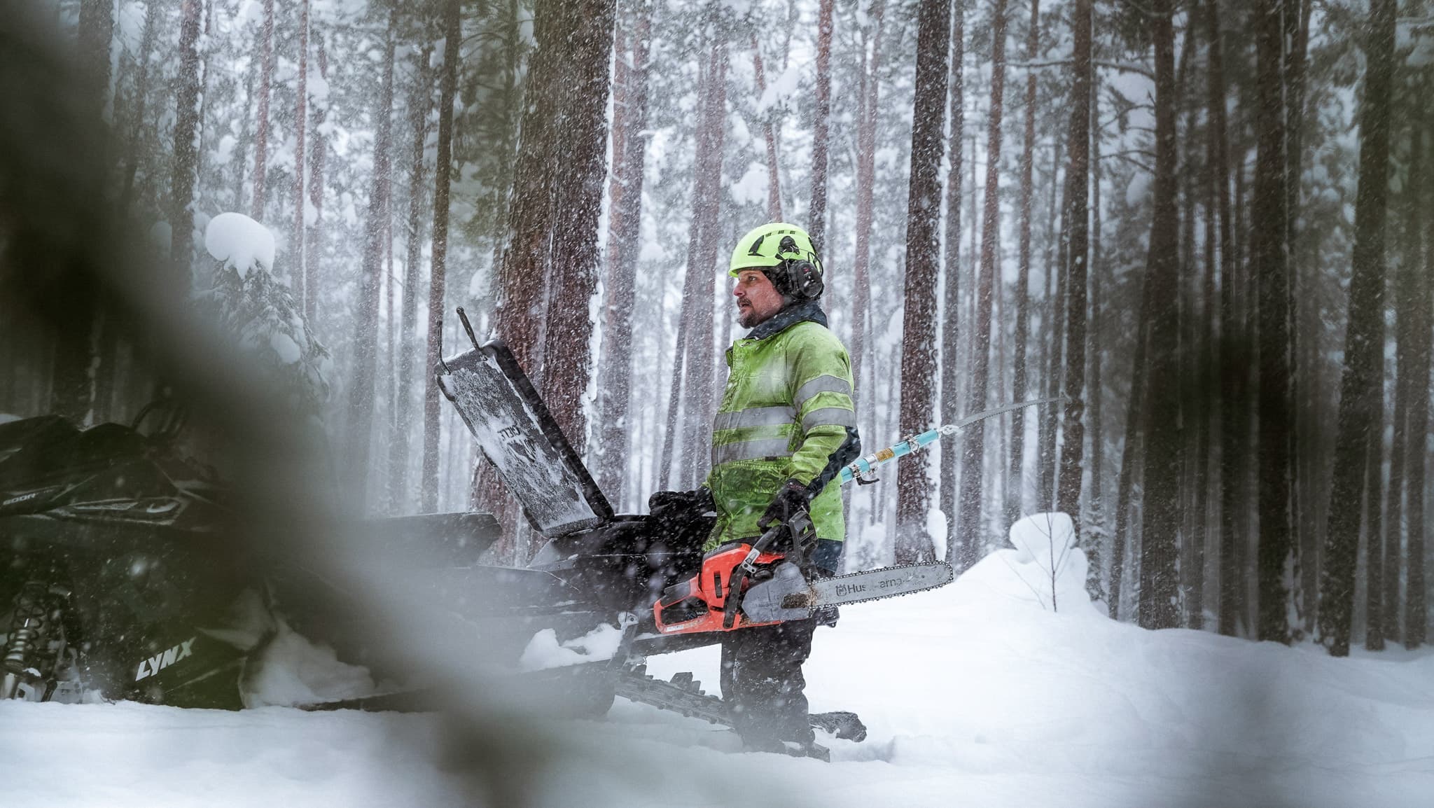 BTEA-personal med skoter och motorsåg. Vi fäller träd som lutar mot elledningar så att det inte ska bli strömavbrott.