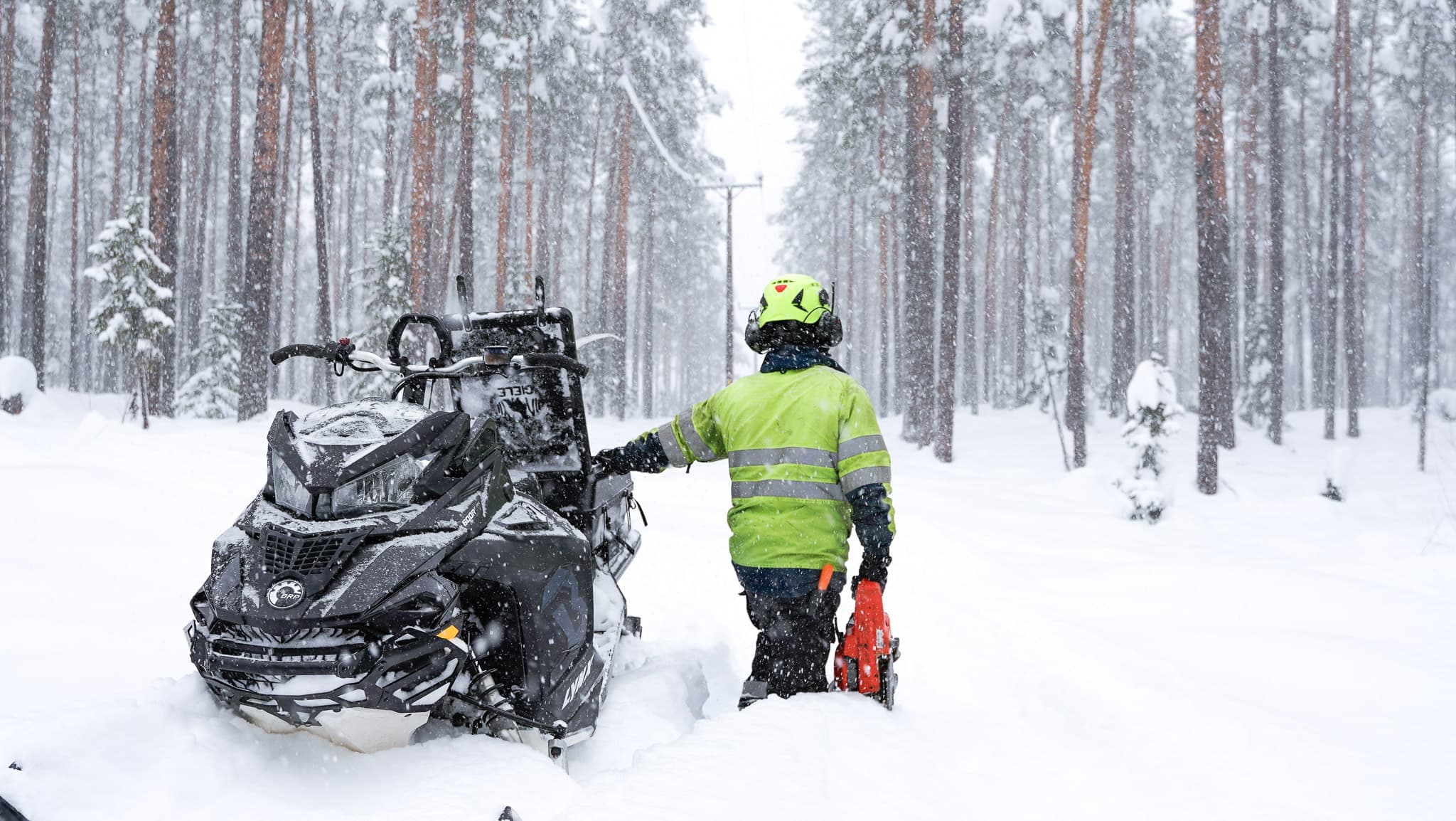 BTEA-personal på skoter under en vinterarbetsdag i skogen, inspekterar elledningar för att säkerställa drift och pålitlighet.