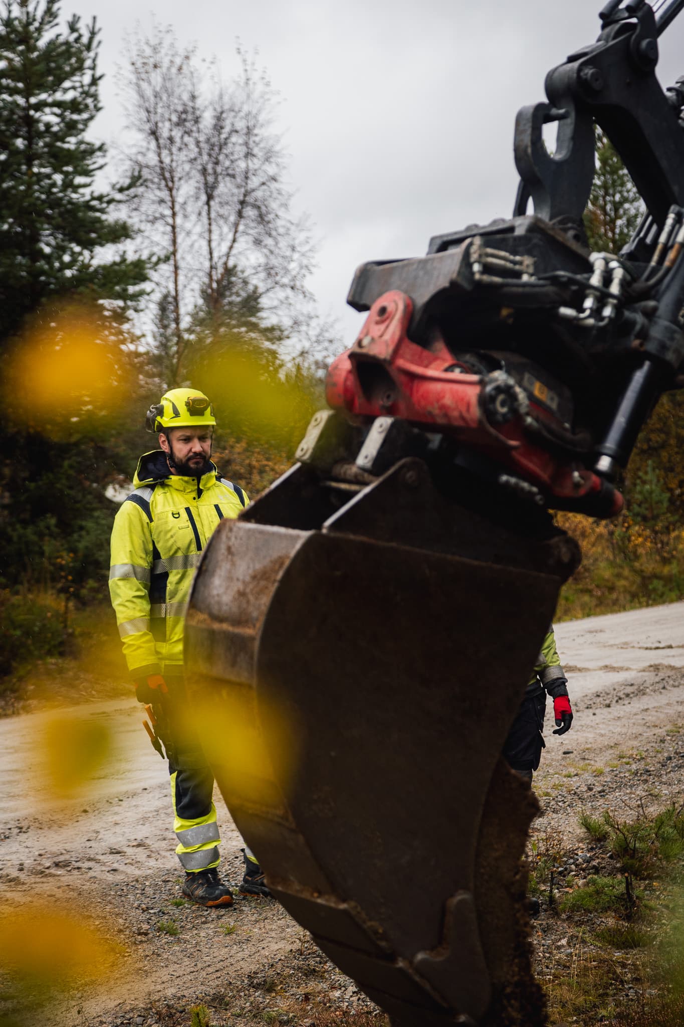 Skopa på en traktorgrävare framför BTEA-personal som arbetar med underhåll och utveckling av elnät och fjärrvärme i Jämtland.