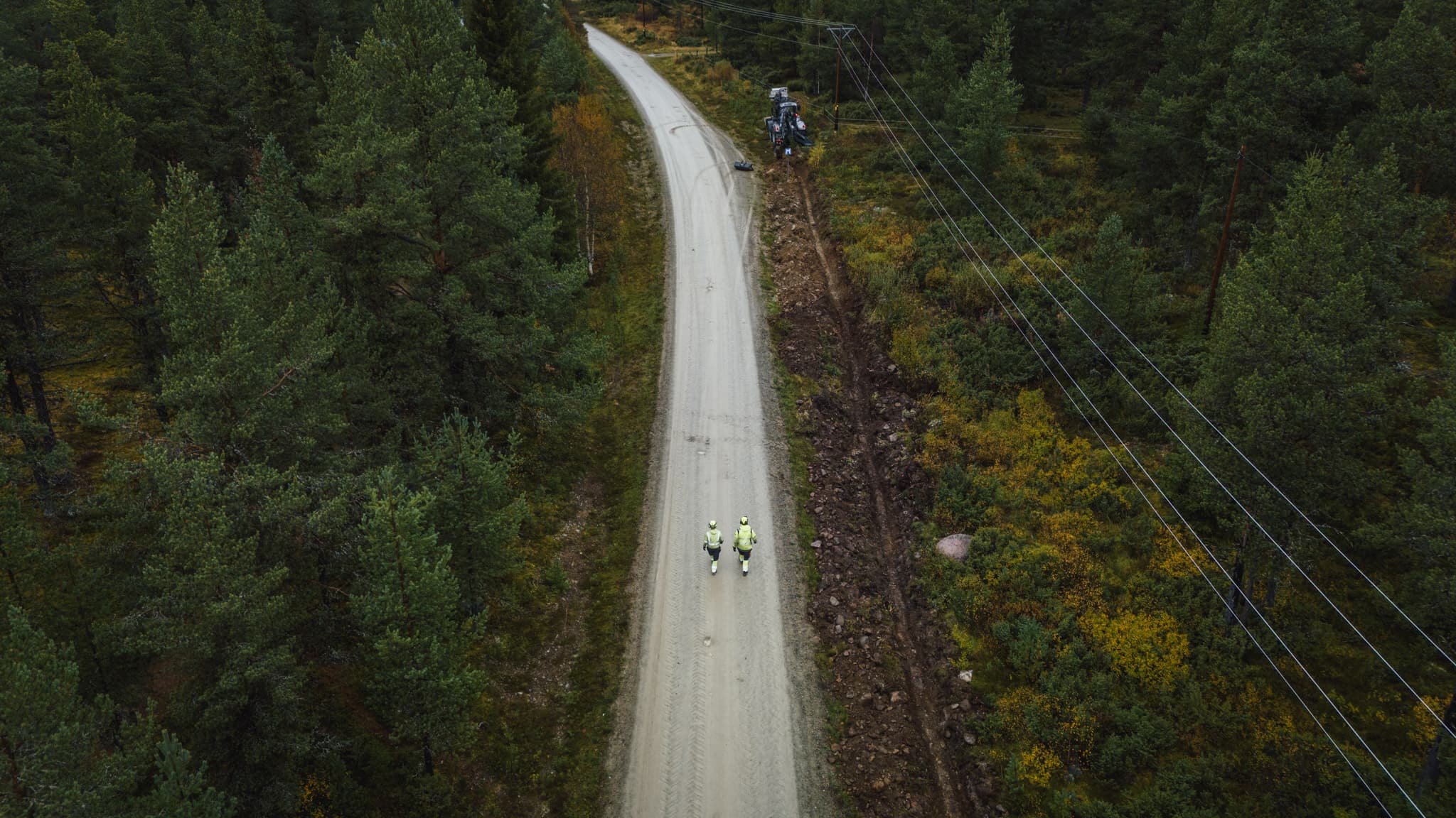 Medarbetare från BTEA går längs en väg vid elledningar. BTEA är ett elnätsbolag.