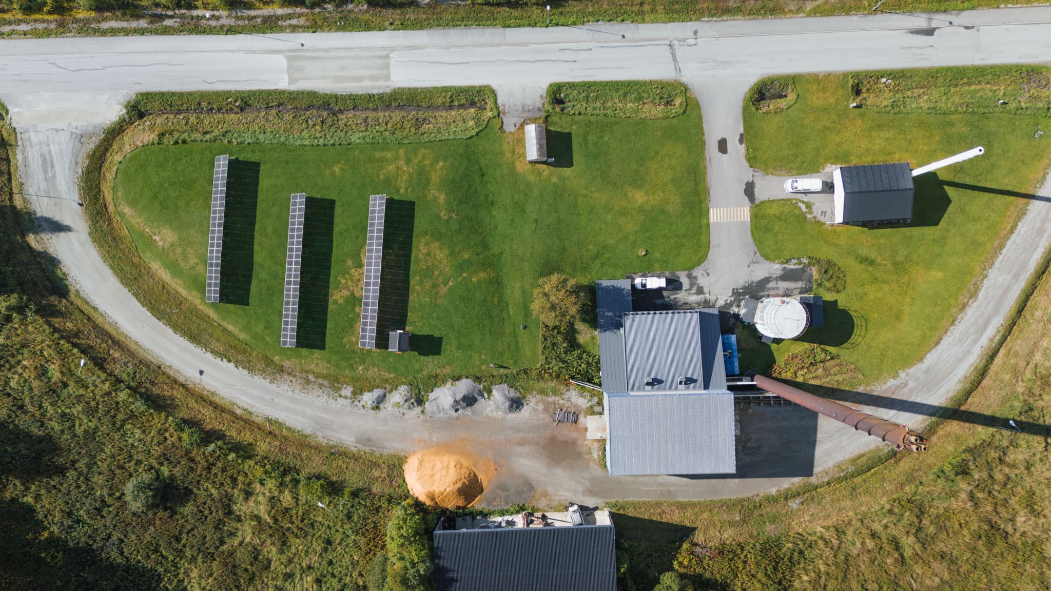 Värmeverk i Svenstavik sett ovanifrån, med solceller på gräsmattan bredvid fjärrvärmeanläggningen.